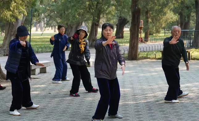 FILE - People exercise at a park near the Temple of Heaven in Beijing on April 2, 2024.(AP Photo/Tatan Syuflana, File)