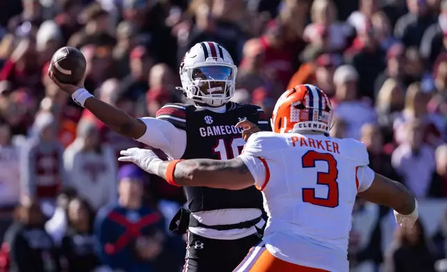South Carolina quarterback Lanorris Sellers (16) throws under pressure from Clemson defensive end T.J. Parker (3) during the first half of an NCAA college football game, Saturday, Nov. 29, 2025, in Columbia, S.C. (AP Photo/Scott Kinser)