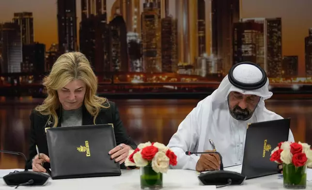 Stephanie Pope, President and CEO of Boeing Commercial Airplanes, left, and Sheikh Ahmed bin Saeed Al Maktoum, President, Dubai Civil Aviation Authority and Chairman of Emirates airlines, sign an agreement to order 65 additional Boeing 777X aircrafts, during a press conference on the opening day of the Dubai Air Show, United Arab Emirates, Monday, Nov. 17, 2025. (AP Photo/Altaf Qadri)