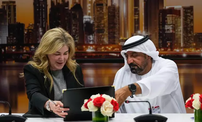 Stephanie Pope, President and CEO of Boeing Commercial Airplanes, left, and Sheikh Ahmed bin Saeed Al Maktoum, President, Dubai Civil Aviation Authority and Chairman of Emirates airlines, sign an agreement to order 65 additional Boeing 777X aircrafts during a press conference on the opening day of the Dubai Air Show, United Arab Emirates, Monday, Nov. 17, 2025. (AP Photo/Altaf Qadri)