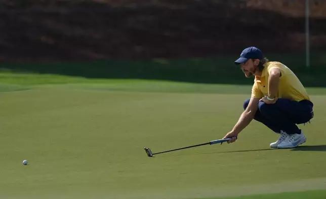 Tommy Fleetwood of England lines up a putt on the 1st green during the third round of World Tour Golf Championship at Jumeirah Golf Estates, in Dubai, United Arab Emirates, Saturday, Nov. 15, 2025. (AP Photo/Altaf Qadri)