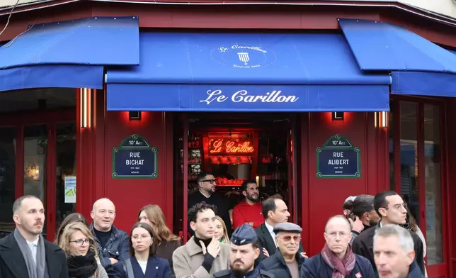 People gather outside "Le Carillon" before a tribute to victims Thursday Nov. 13, 2025 in Paris for ceremonies marking the 10th anniversary of terrorist attacks that killed 132 people and injured hundreds. (Ludovic Marin, Pool photo via AP)