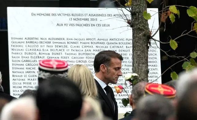 French President Emmanuel Macron walks past the plaque engraved with the names of the victims outside the Bataclan concert hall as Paris is marking the 10th anniversary of terrorist attacks that killed 132 people and injured hundreds, Thursday, Nov. 13, 2025 in Paris. (AP Photo/Michel Euler)