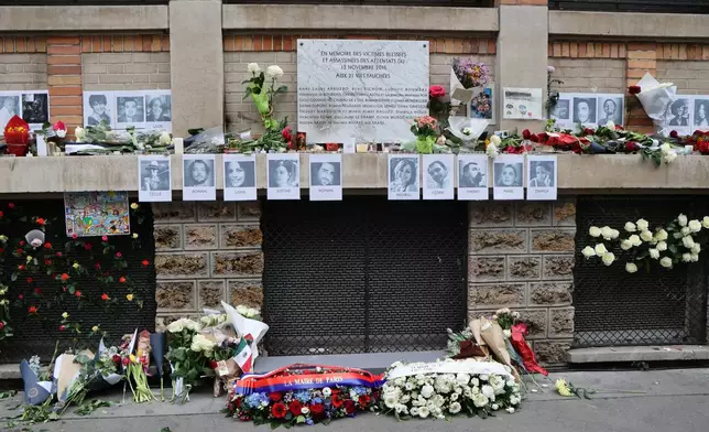 Flowers and photographs of victims near are placed near La Bonne Biere cafe, Thursday Nov. 13, 2025 in Paris as part of ceremonies marking the 10th anniversary of terrorist attacks that killed 132 people and injured hundreds. (Ludovic Marin, Pool photo via AP)