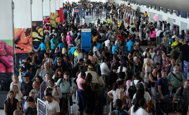 Passengers check in at the Norman Manley International Airport in Kingston, Jamaica, Saturday, Nov. 1, 2025, in the aftermath of Hurricane Melissa. (AP Photo/Matias Delacroix)