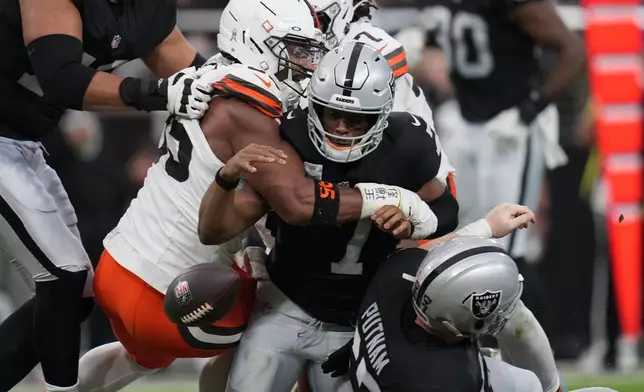 Cleveland Browns defensive end Myles Garrett (95) forces Las Vegas Raiders quarterback Geno Smith (7) to fumble during the first half of an NFL football game Sunday, Nov. 23, 2025, in Las Vegas. (AP Photo/Eric Gay)