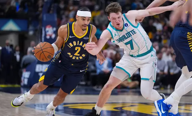 Indiana Pacers forward Andrew Nembhard (2) drives around Charlotte Hornets guard Kon Knueppel (7) during the second half of an NBA basketball game in Indianapolis, Wednesday, Nov. 19, 2025. (AP Photo/Michael Conroy)
