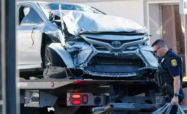 A vehicle that crashed into a local business is towed away, while law enforcement investigate the scene on Saturday, Nov. 8, 2025, in Tampa, Fla. (Jefferee Woo/Tampa Bay Times via AP)