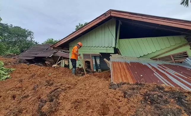 In this photo released on Saturday, Nov. 29, 2025 by the Indonesian National Search and Rescue Agency (BASARNAS), rescuers search for victims at a village hit by a landslide in Batu Goading, North Sumatra, Indonesia. (BASARNAS via AP)