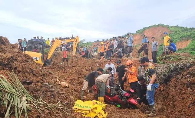 In this photo released on Saturday, Nov. 29, 2025 by the Indonesian National Search and Rescue Agency (BASARNAS), rescuers remove a scooter buried in the mud as they search for victims at a village hit by a landslide in Batu Goading, North Sumatra, Indonesia. (BASARNAS via AP)