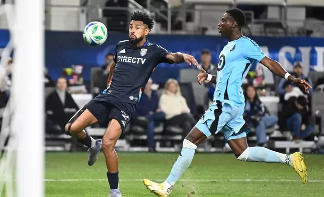 San Diego FC midfielder Anibal Godoy (20) shoots past Minnesota United forward Kelvin Yeboah (9) during the first half of MLS soccer's Western Conference semifinal Monday, Nov. 24, 2025, in San Diego. (AP Photo/Denis Poroy)