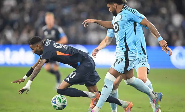 San Diego FC forward Amahl Pellegrino (90) goes down in front of Minnesota United midfielder Carlos Harvey (67) during the first half of MLS soccer's Western Conference semifinal Monday, Nov. 24, 2025, in San Diego. (AP Photo/Denis Poroy)
