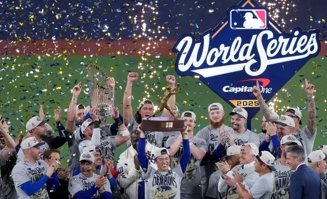 World Series MVP Los Angeles Dodgers' Yoshinobu Yamamoto holds his trophy as teammates celebrate their win in Game 7 of baseball's World Series against the Toronto Blue Jays, Sunday, Nov. 2, 2025, in Toronto. (AP Photo/Ashley Landis)