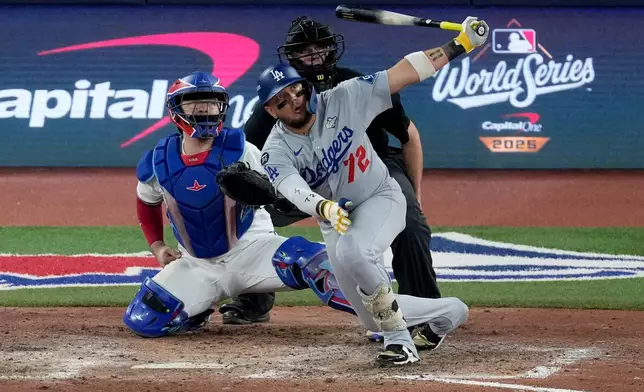 Los Angeles Dodgers' Miguel Rojas follows through on a home run against the Toronto Blue Jays during the ninth inning in Game 7 of baseball's World Series, Saturday, Nov. 1, 2025, in Toronto. (AP Photo/Ashley Landis)