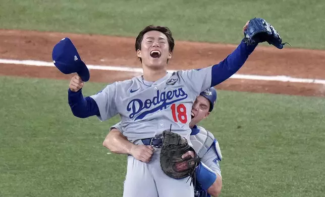 Los Angeles Dodgers' Will Smith, right, celebrates with Yoshinobu Yamamoto (18) after the team defeated the Toronto Blue Jays in Game 7 of baseball's World Series, Sunday, Nov. 2, 2025, in Toronto. (Chris Young/The Canadian Press via AP)