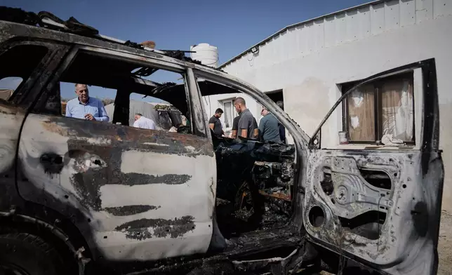 Palestinians survey damage in an industrial zone following an attack by Israeli settlers the previous day in the West Bank village of Beit Lid, near Tulkarm, Wednesday, Nov. 12, 2025. (AP Photo/Majdi Mohammed)
