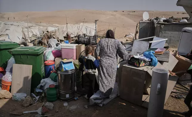 Members of the Hamamdeh family gather their belongings after Israeli authorities demolished their home in the West Bank village of Masafer Yatta Wednesday, Nov. 12, 2025. (AP Photo/Mahmoud Illean)