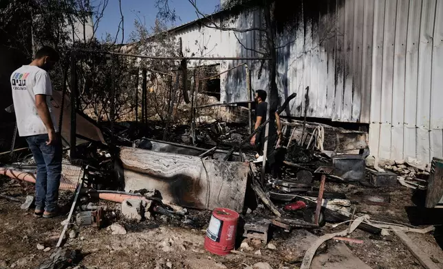 Palestinians survey damage in an industrial zone following an attack by Israeli settlers the previous day in the West Bank village of Beit Lid, near Tulkarm, Wednesday, Nov. 12, 2025. (AP Photo/Majdi Mohammed)