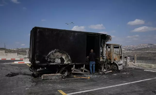 Palestinians survey damage in an industrial zone following an attack by Israeli settlers the previous day in the West Bank village of Beit Lid, near Tulkarm, Wednesday, Nov. 12, 2025. (AP Photo/Majdi Mohammed)