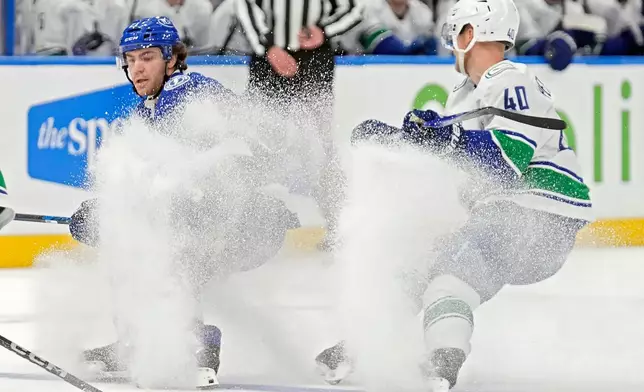 Tampa Bay Lightning center Brayden Point (21) stops in front of Vancouver Canucks center Elias Pettersson (40) during the second period of an NHL hockey game Sunday, Nov. 16, 2025, in Tampa, Fla. (AP Photo/Chris O'Meara)