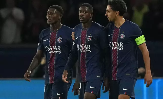 PSG's Nuno Mendes, from left, Ousmane Dembele and Marquinhos react during the Champions League opening phase soccer match between Paris Saint-Germain and Bayern Munich in Paris, France, Tuesday, Nov. 4, 2025. (AP Photo/Thibault Camus)