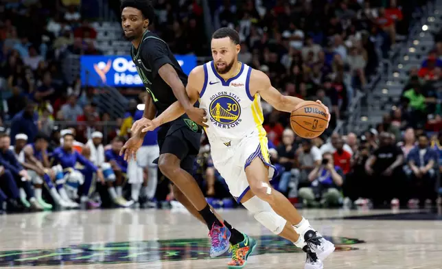Golden State Warriors guard Stephen Curry (30) drives to the basket around New Orleans Pelicans forward Herbert Jones during the second quarter of an NBA basketball game, Sunday, Nov. 16, 2025, in New Orleans. (AP Photo/Butch Dill)
