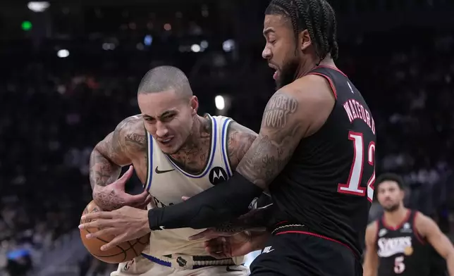 Philadelphia 76ers' Trendon Watford knocks the ball from Milwaukee Bucks' Kyle Kuzma during the first half of an NBA basketball game Thursday, Nov. 20, 2025, in Milwaukee. (AP Photo/Morry Gash)