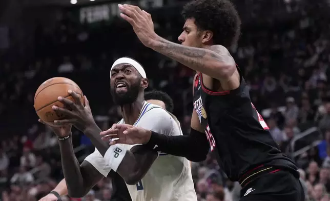 Milwaukee Bucks' Bobby Portis tries to shoot past Philadelphia 76ers' Dominick Barlow during the first half of an NBA basketball game Thursday, Nov. 20, 2025, in Milwaukee. (AP Photo/Morry Gash)
