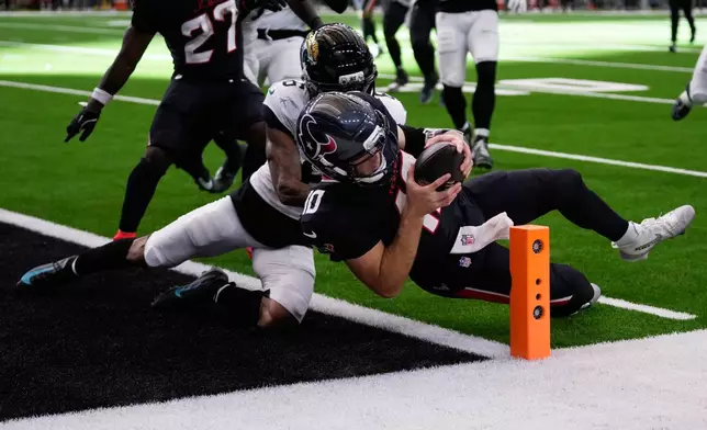 Houston Texans quarterback Davis Mills (10) scores a touchdown against Jacksonville Jaguars cornerback Greg Newsome II (6) during the second half of an NFL football game, Sunday, Nov. 9, 2025, in Houston. (AP Photo/Eric Christian Smith)
