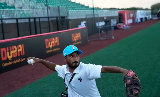 A journalist throws a ball after a press presentation ahead of the league's inaugural season at the new Barry Larkin Field in Ud al-Bayda, on the outskirts of Dubai, United Arab Emirates, Thursday, Nov. 13, 2025. (AP Photo/Fatima Shbair)