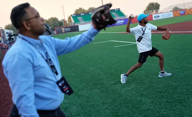 Journalists throw a few balls after a press presentation ahead of the league's inaugural season at the new Barry Larkin Field in Ud al-Bayda, on the outskirts of Dubai, United Arab Emirates, Thursday, Nov. 13, 2025. (AP Photo/Fatima Shbair)