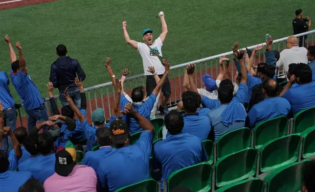 Karachi fans react during the league's opening baseball game at the new Barry Larkin Field in Ud al-Bayda, on the outskirts of Dubai, United Arab Emirates, Friday, Nov. 14, 2025. (AP Photo/Fatima Shbair)