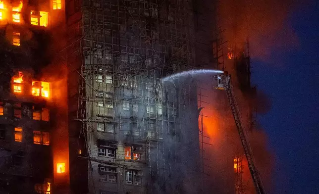 Firefighters try to extinguish a fire which broke out at Wang Fuk Court, a residential estate in the Tai Po district of Hong Kong's New Territories, Wednesday, Nov. 26 2025. (AP Photo/Chan Long Hei)
