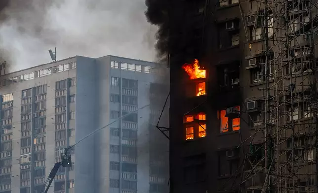 Firefighters work the scene of a fire at Wang Fuk Court, a residential estate in the Tai Po district of Hong Kong's New Territories, on Wednesday, Nov. 26 2025. (AP Photo/Chan Long Hei)
