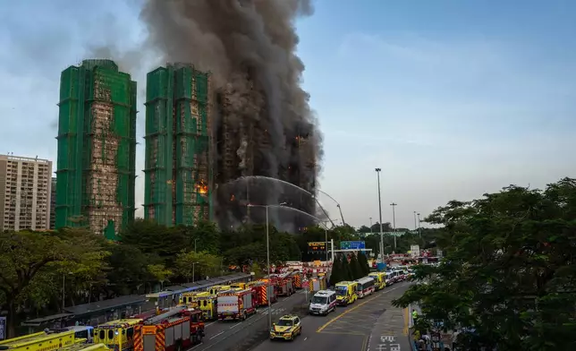 Firefighters try to extinguisha fire that broke out at Wang Fuk Court, a residential estate in the Tai Po district of Hong Kong's New Territories, Wednesday, Nov. 26 2025. (AP Photo/Chan Long Hei)