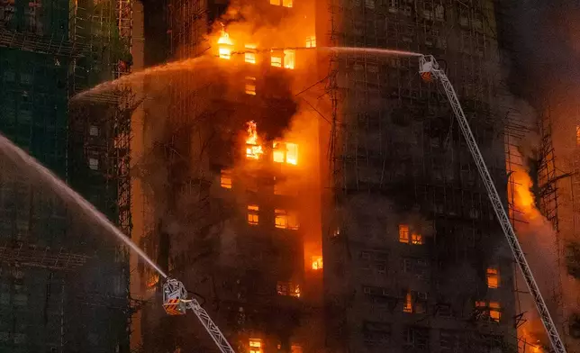 Firefighters try to extinguish a flames engulfing a building after a fire broke out at Wang Fuk Court, a residential estate in the Tai Po district of Hong Kong's New Territories, Wednesday, Nov. 26 2025. (AP Photo/Chan Long Hei)
