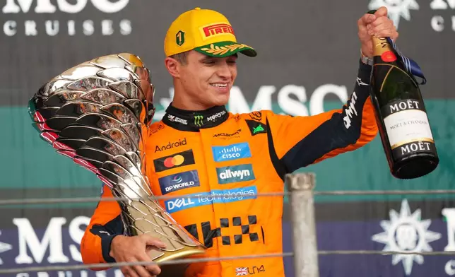 McLaren driver Lando Norris of Britain celebrates on the podium his first place in the Brazilian Formula One Grand Prix at the Interlagos race track in Sao Paulo, Sunday, Nov. 9, 2025. (AP Photo/Andre Penner)