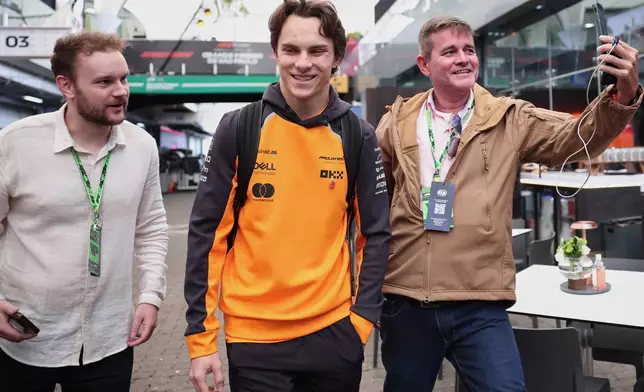 McLaren driver Oscar Piastri of Australia, center, arrives at the Interlagos race track ahead of the Brazilian Formula One Grand Prix in Sao Paulo, Sunday, Nov. 9, 2025. (AP Photo/Ettore Chiereguini)