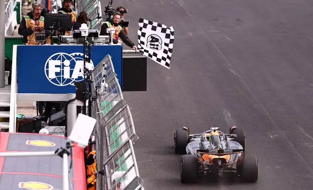 The checkered flag is waved as McLaren driver Lando Norris of Britain crosses the finish line to win the Brazilian Formula One Grand Prix at the Interlagos race track in Sao Paulo, Sunday, Nov. 9, 2025. (Jean Carniel /Pool Photo via AP)