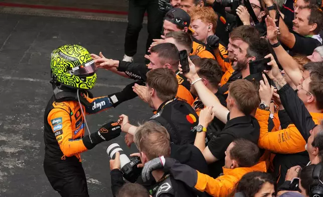 McLaren driver Lando Norris of Britain celebrates with teammates after winning the Brazilian Formula One Grand Prix at the Interlagos race track in Sao Paulo, Sunday, Nov. 9, 2025. (AP Photo/Andre Penner)