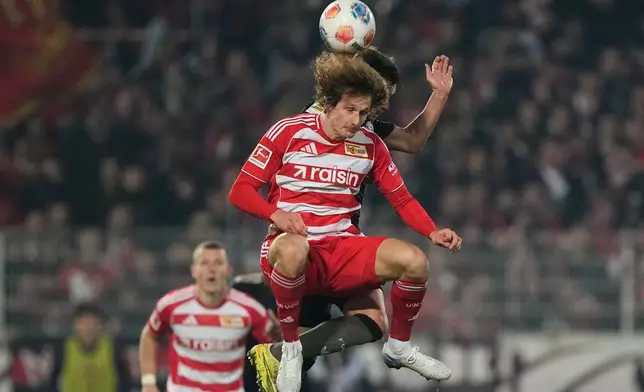Union's Alex Kral, foreground, and Bayern's Joshua Kimmich challenge for the ball during the Bundesliga soccer match between Union Berlin and FC Bayern Munich in Berlin, Germany, Saturday, Nov. 8, 2025. (AP Photo/Martin Meissner)