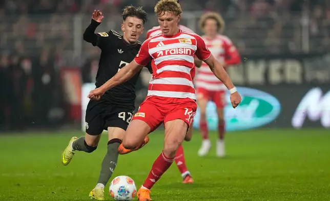 Bayern's Lennart Karl, left, Union's Leopold Querfeld challenge for the ball during the Bundesliga soccer match between Union Berlin and FC Bayern Munich in Berlin, Germany, Saturday, Nov. 8, 2025. (AP Photo/Martin Meissner)
