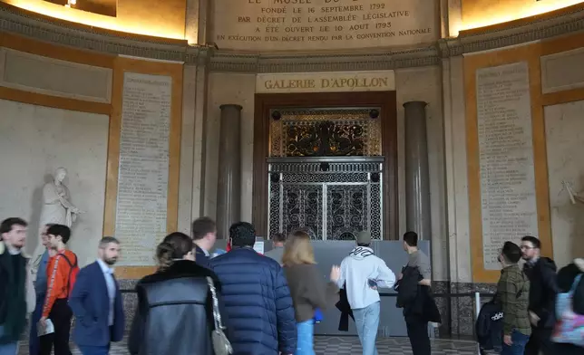 Visiors walk past the closed Apollo gallery of Le Louvre museum, Wednesday, Nov. 19, 2025 in Paris. (AP Photo/Christophe Ena)