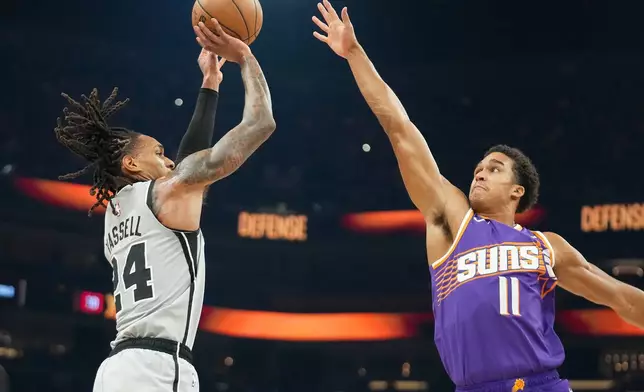 San Antonio Spurs guard Devin Vassell (24) looks to shoot against San Antonio Spurs forward Carter Bryant (11) during the first half of an NBA basketball game in Phoenix, Sunday, Nov. 23, 2025. (AP Photo/Darryl Webb)