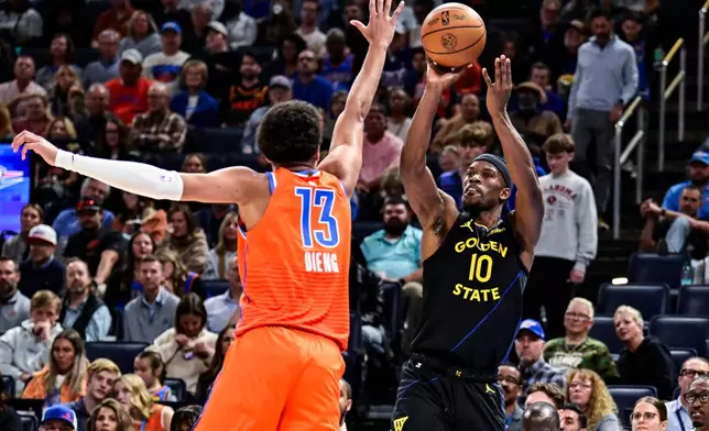 Golden State Warriors forward Jimmy Butler III (10) shoots against Oklahoma City Thunder forward Ousmane Dieng (13) during the first half of an NBA basketball game, Tuesday, Nov. 11, 2025, in Oklahoma City. (AP Photo/Gerald Leong)