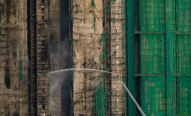 Firefighters work to extinguish a fire which broke out Wednesday at Wang Fuk Court, a residential estate in the Tai Po district of Hong Kong's New Territories, Thursday, Nov. 27, 2025. (AP Photo/Chan Long Hei)