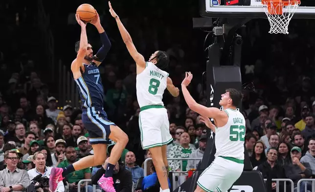 Memphis Grizzlies forward Santi Aldama (7) looks to pass while covered by Boston Celtics forward Josh Minott (8) during the first half of an NBA basketball game, Wednesday, Nov. 12, 2025, in Boston. (AP Photo/Charles Krupa)