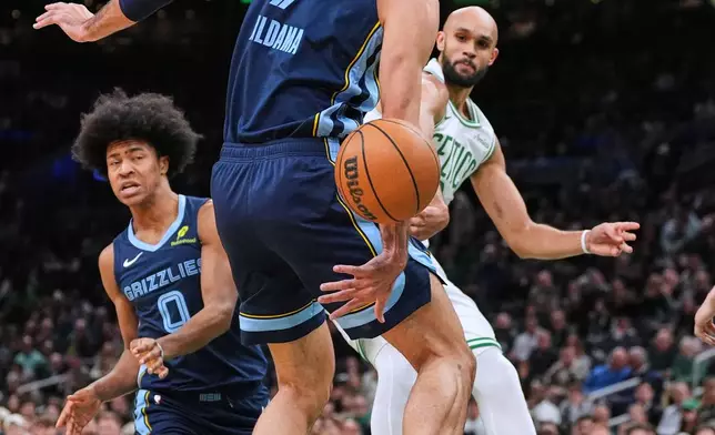 Boston Celtics guard Derrick White, right, passes the ball while pressured by Memphis Grizzlies forward Santi Aldama (7) during the first half of an NBA basketball game, Wednesday, Nov. 12, 2025, in Boston. (AP Photo/Charles Krupa)