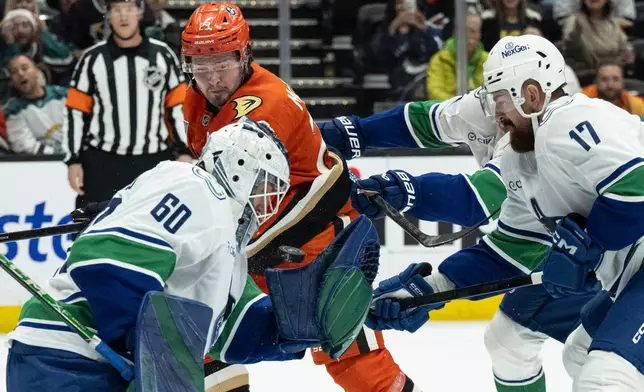 Vancouver Canucks goaltender Nikita Tolopilo (60) bobbles the puck during the first period of an NHL hockey game against the Anaheim Ducks, Wednesday, Nov. 26, 2025, in Anaheim, Calif. (AP Photo/Kyusung Gong)