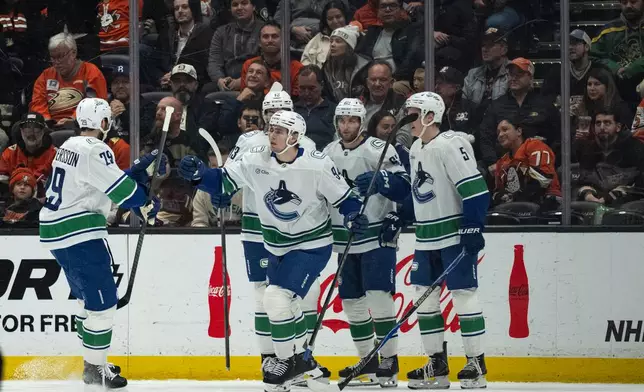 Vancouver Canucks players celebrate a goal by center Linus Karlsson (94) during the first period of an NHL hockey game against the Anaheim Ducks, Wednesday, Nov. 26, 2025, in Anaheim, Calif. (AP Photo/Kyusung Gong)